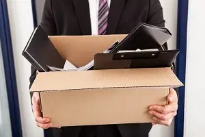 Businessman carrying belongings in box