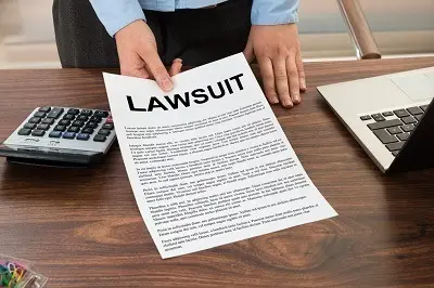 Man holding paper labeled lawsuit