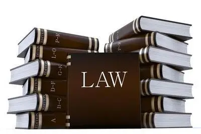 Two piles of leather-bound law books with one book leaning against the two piles, and its cover says "LAW"