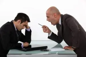 Boss shouting at employee in an office, driving employee to quit