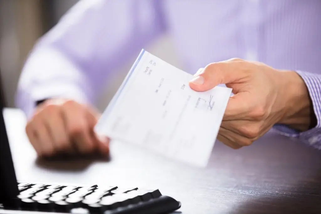 Boss handing paycheck to employee off screen