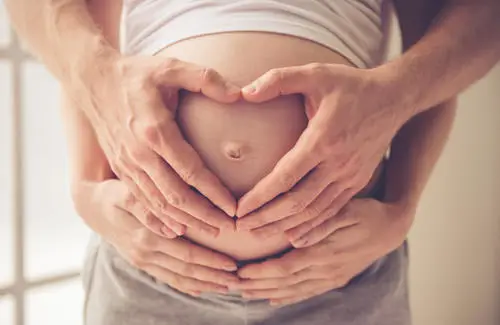 Expecting mom cradling belly while taking PDL. 