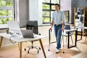 Man on crutches in office