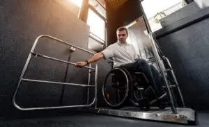 Man in a wheelchair in a special elevator that was provided as a reasonable accommodation for his job