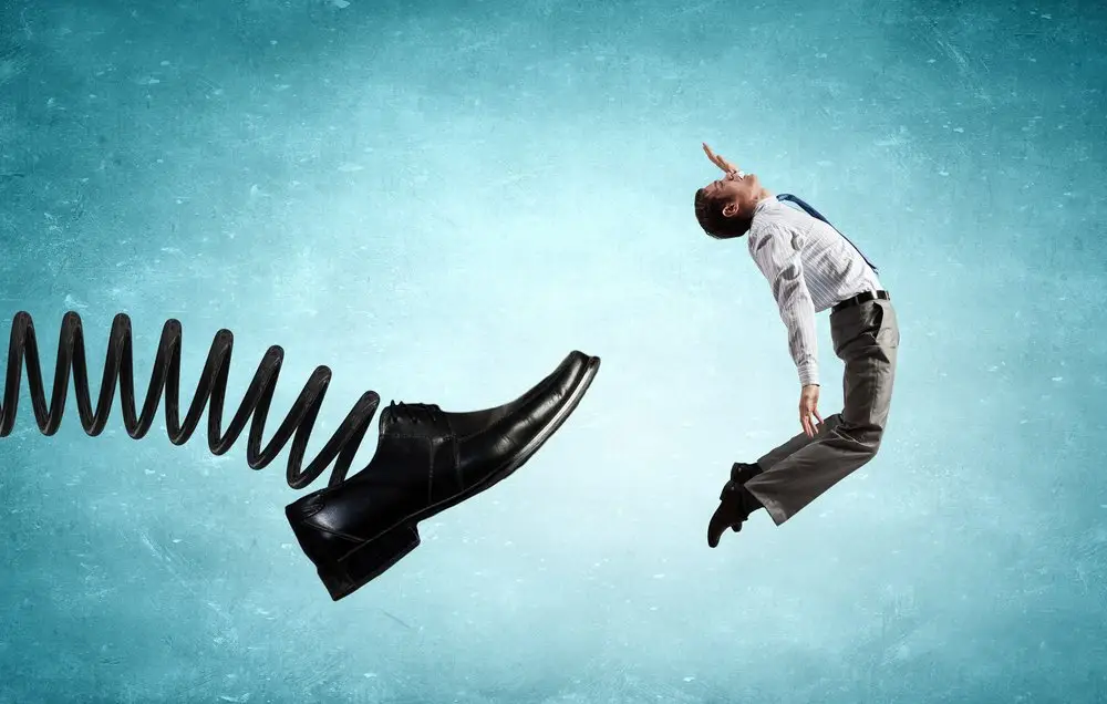 A spring loaded shoe kicking out an employee as a visual metaphor for getting wrongfully fired.