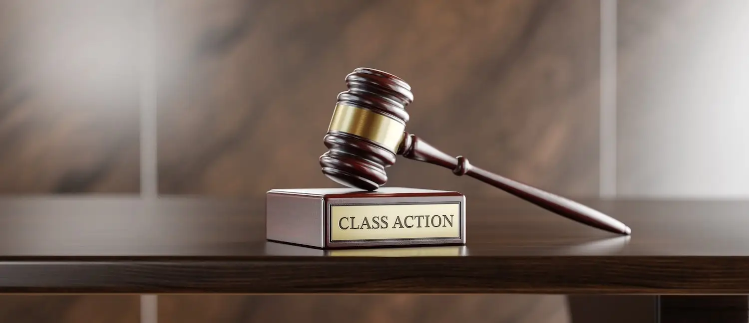 Judge's gavel resting on a surface that says "class action"
