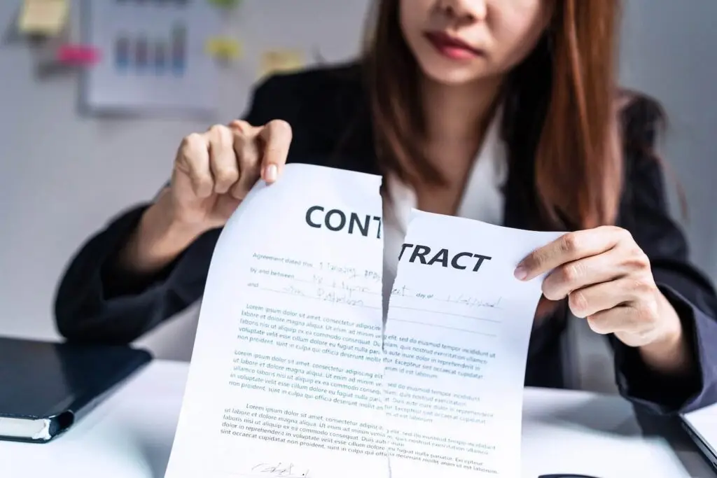 Woman at desk ripping up an employment contract at her desk