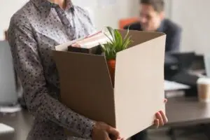 Ex-employee carrying box of office belongings following layoff as defined by Labor Code 1400.5