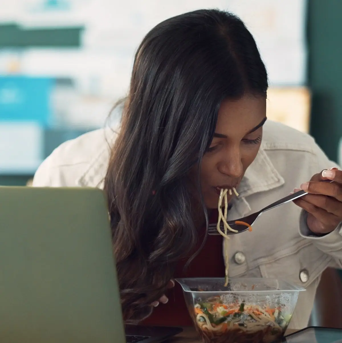 Receptionist scarfing down a salad at her desk at work