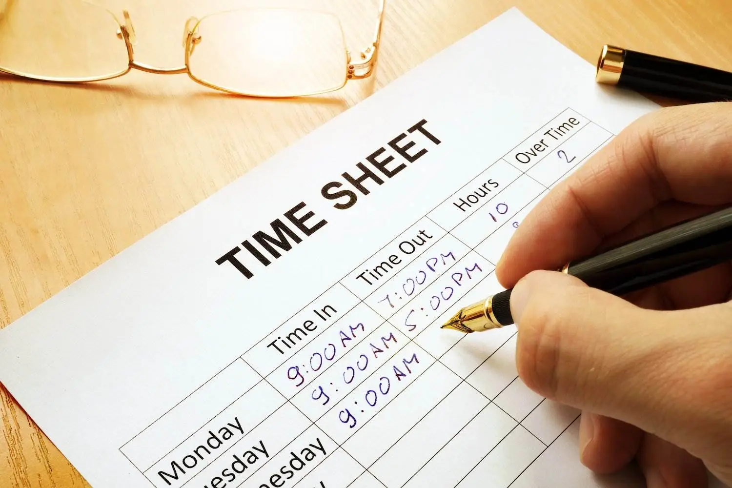 Close up timesheet with human hand writing on it