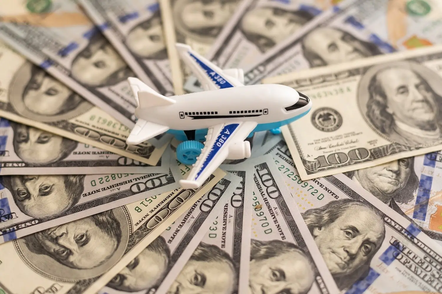 toy plane on a fan of cash on a table