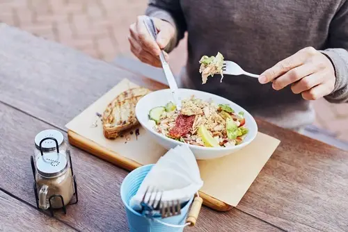 Closeup of worker having a salad during a lunch hour from work