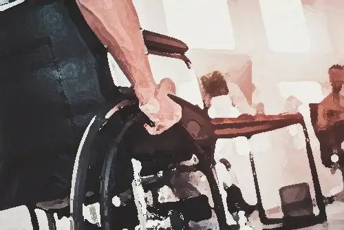 close-up of an employee in a wheelchair in an office, and he is wheeling towards his desk